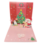 Pop-up Christmas card with Santa Claus, reindeer, and Christmas tree on a red and pink background.